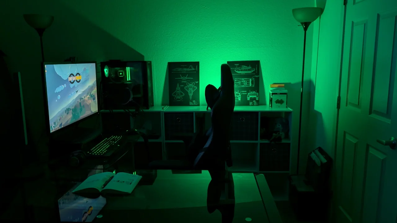 Joe Theis’ workstation with green ambient lighting, dual monitors, and PC setup.