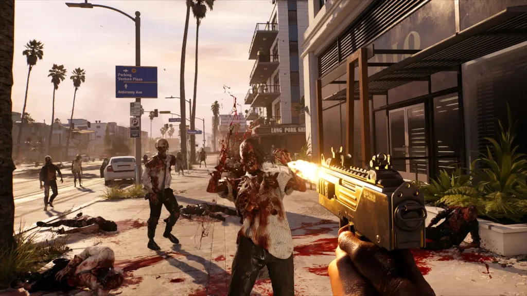A player character in Dead Island 2 fires a weapon at a horde of zombies on a sunlit street with palm trees and buildings.
