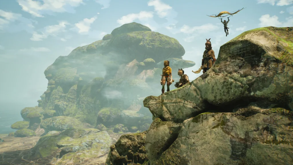 Three characters in tribal-style outfits stand atop a mossy cliff, overlooking misty rock formations, while another player descends using a glider in the distance.
