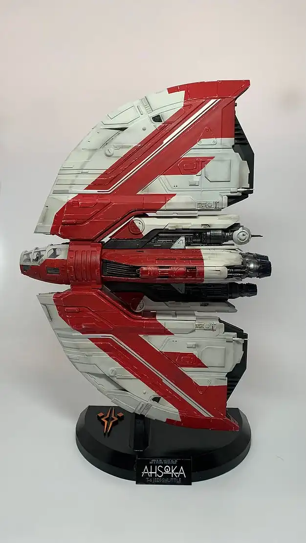 Red-and-white T-6 Jedi Shuttle model displayed on a black stand.