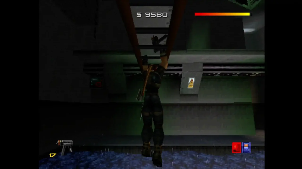 Character hangs from a ledge in a dark indoor area in Fighting Force Collection, with money counter and health bar on-screen.