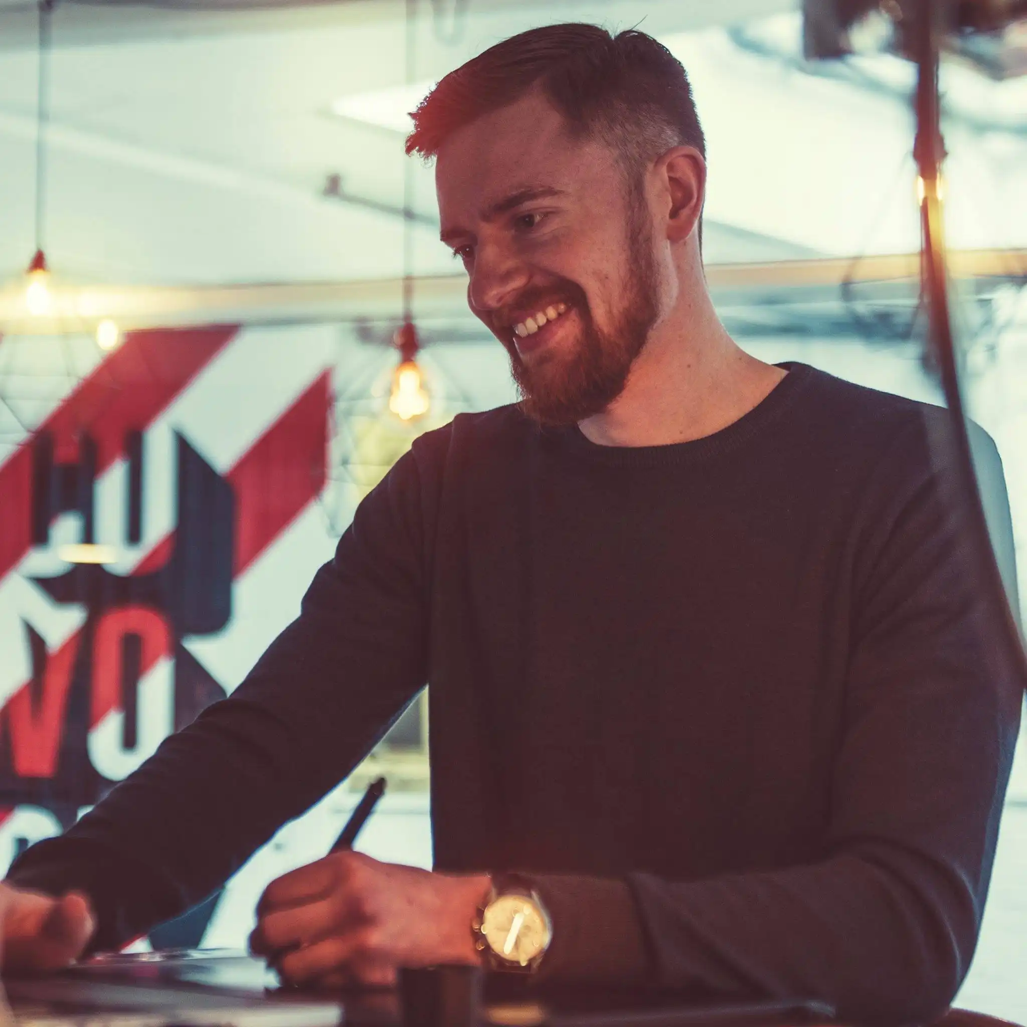 Portrait of illustrator and concept artist Matt Essom smiling while working at a table.