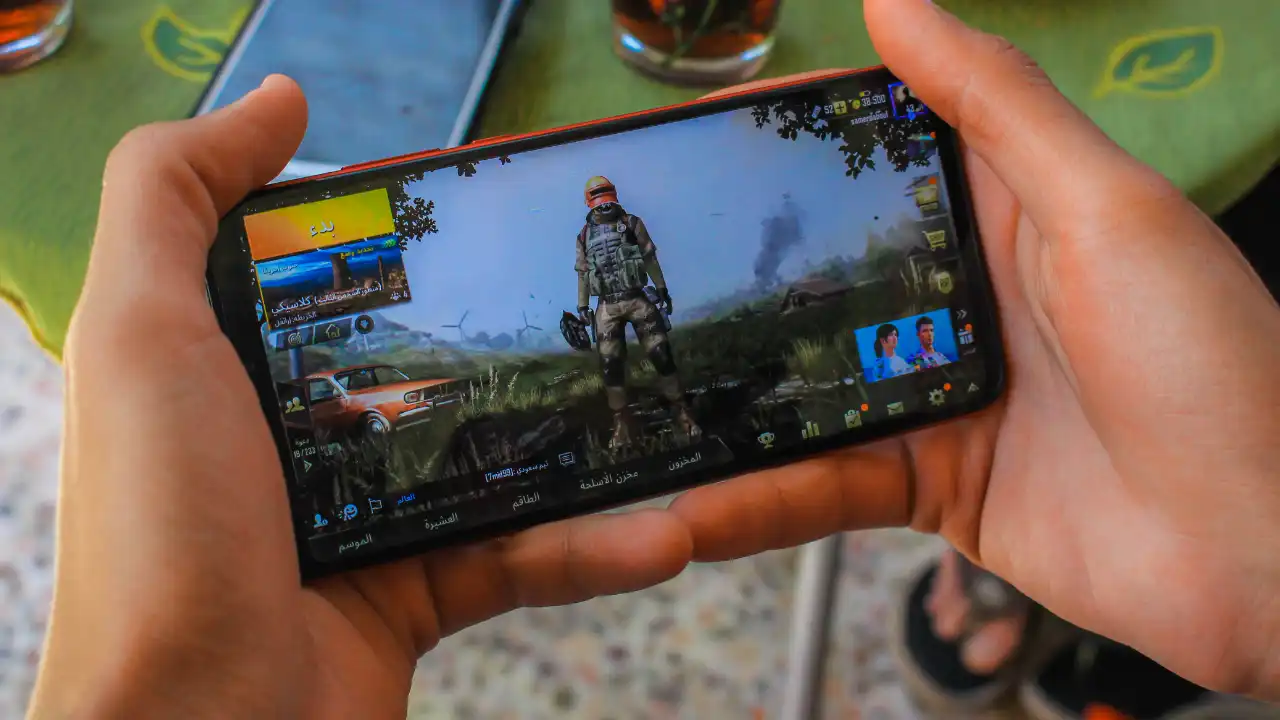 Person playing a mobile shooter on a smartphone, showing how common mobile gaming has become worldwide