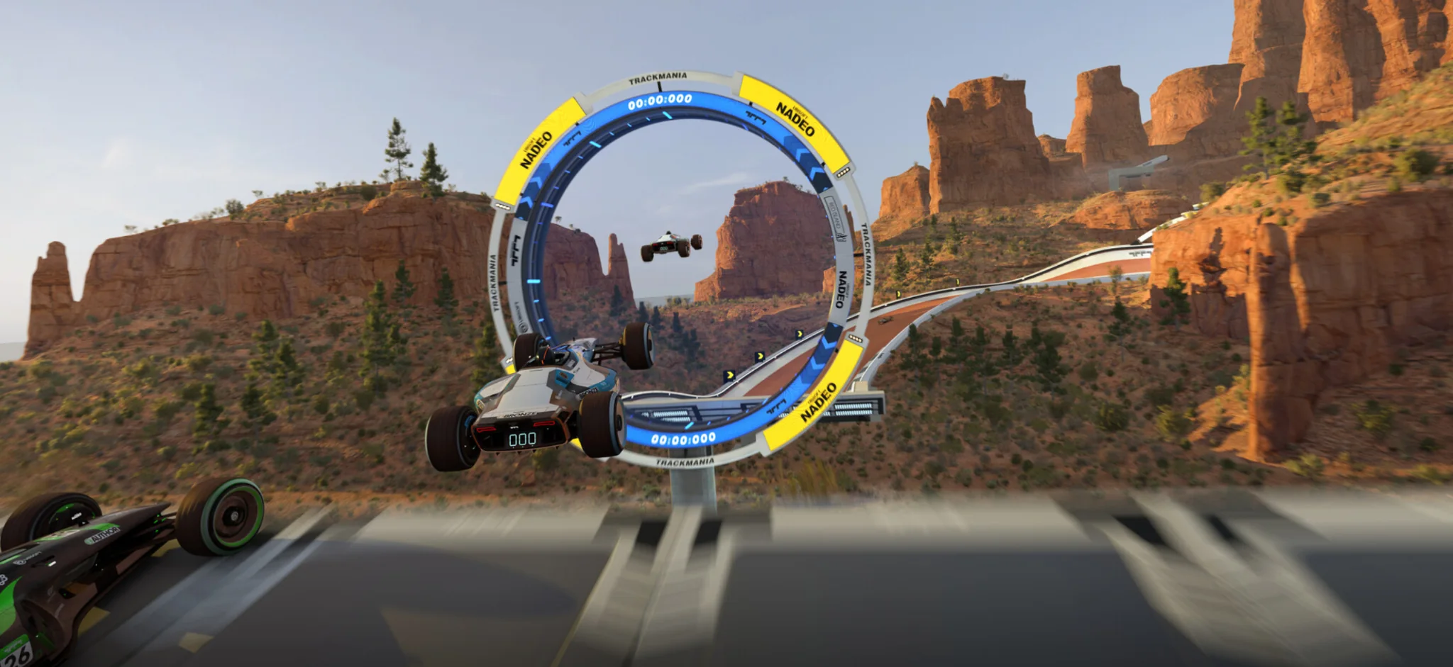 Trackmania racing cars jumping through a checkpoint ring in a desert canyon